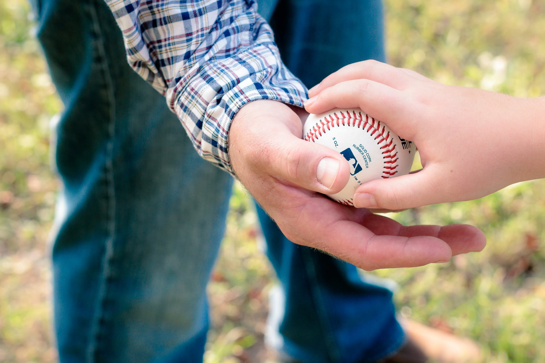 two person holding white baseball ball