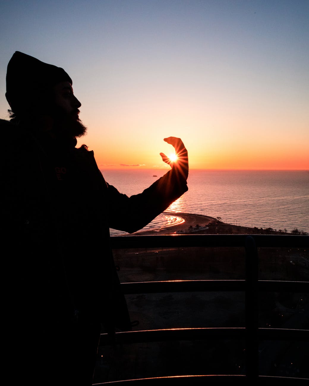 forced perspective photography of man holding the sun