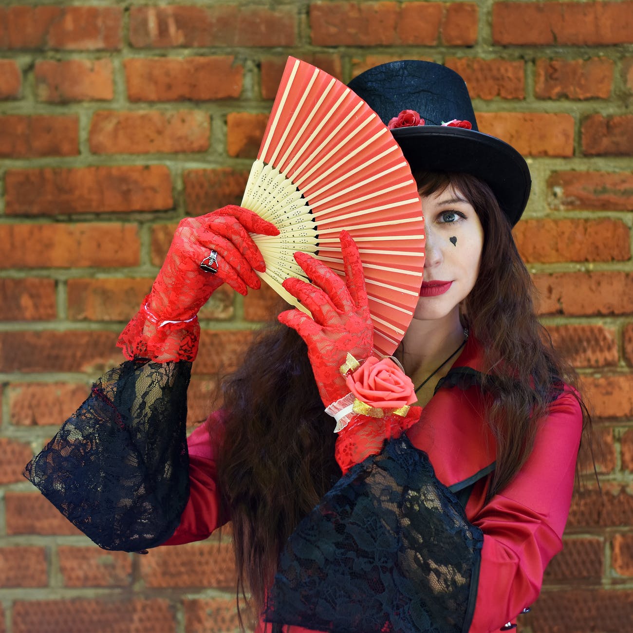 unknown celebrity carrying red and brown folding fan